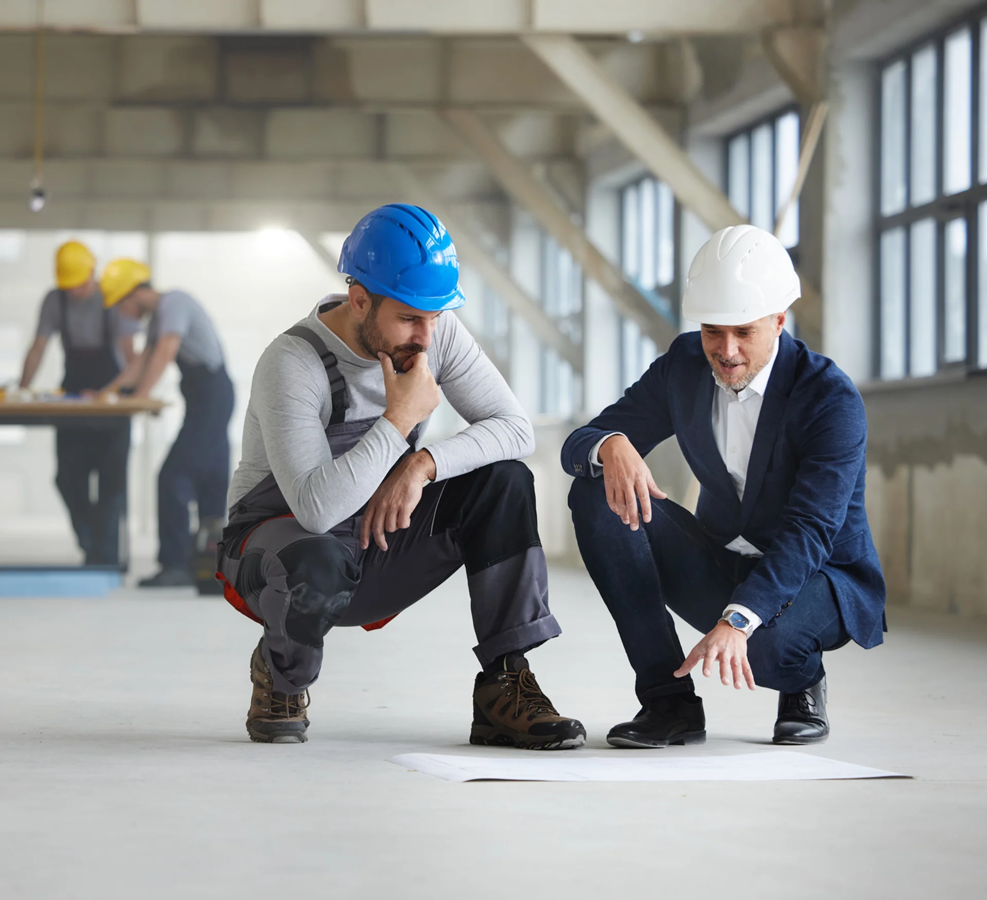 Construction workers reviewing building plans together.