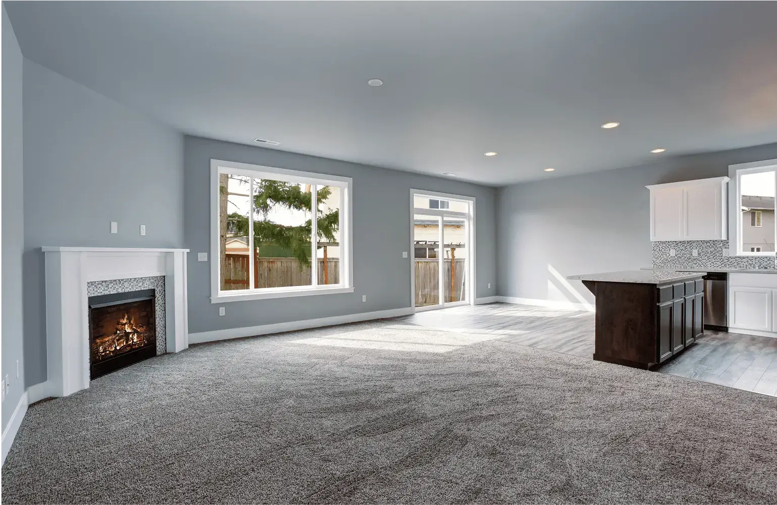 Modern living room with fireplace and kitchen.